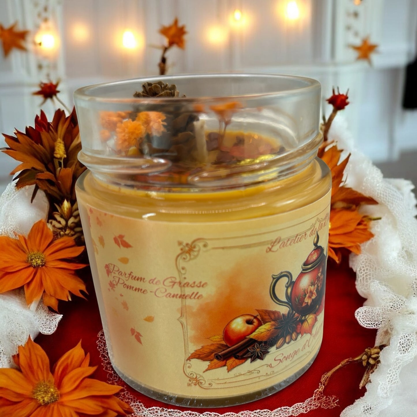 Bougie Songe d’automne in a glass jar surrounded by autumn flowers and decorations.