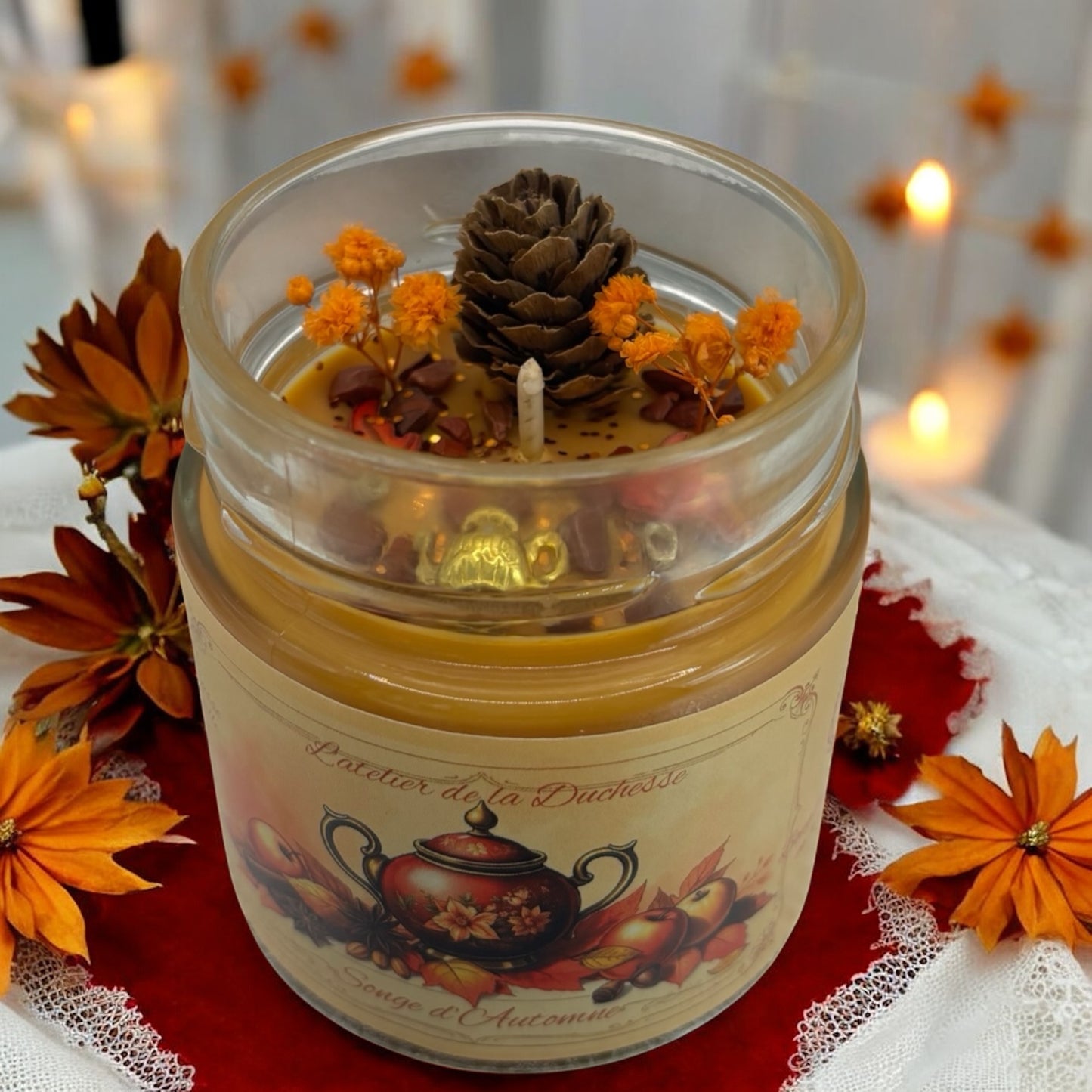 Autumn-themed scented candle with pine cone and orange flowers, creating a cozy ambiance for seasonal decor.