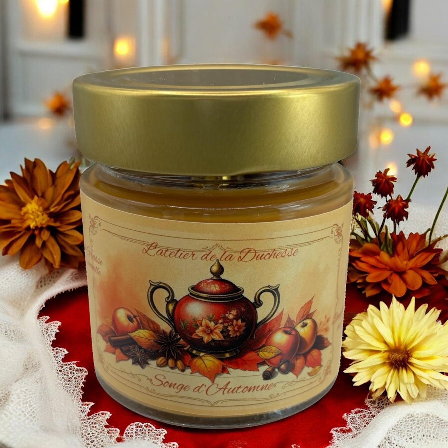 Decorative jar candle labeled 'Songe d'Automne' surrounded by autumn flowers and warm lighting.