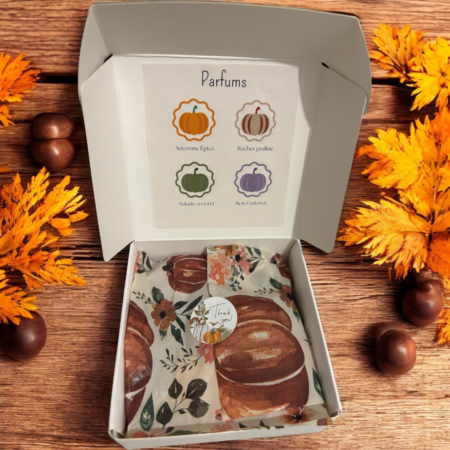 Boîte fondants Les Plaisirs d’Automne ouverte, contenant des fondants parfumés en forme de citrouilles et décorations automnales.
