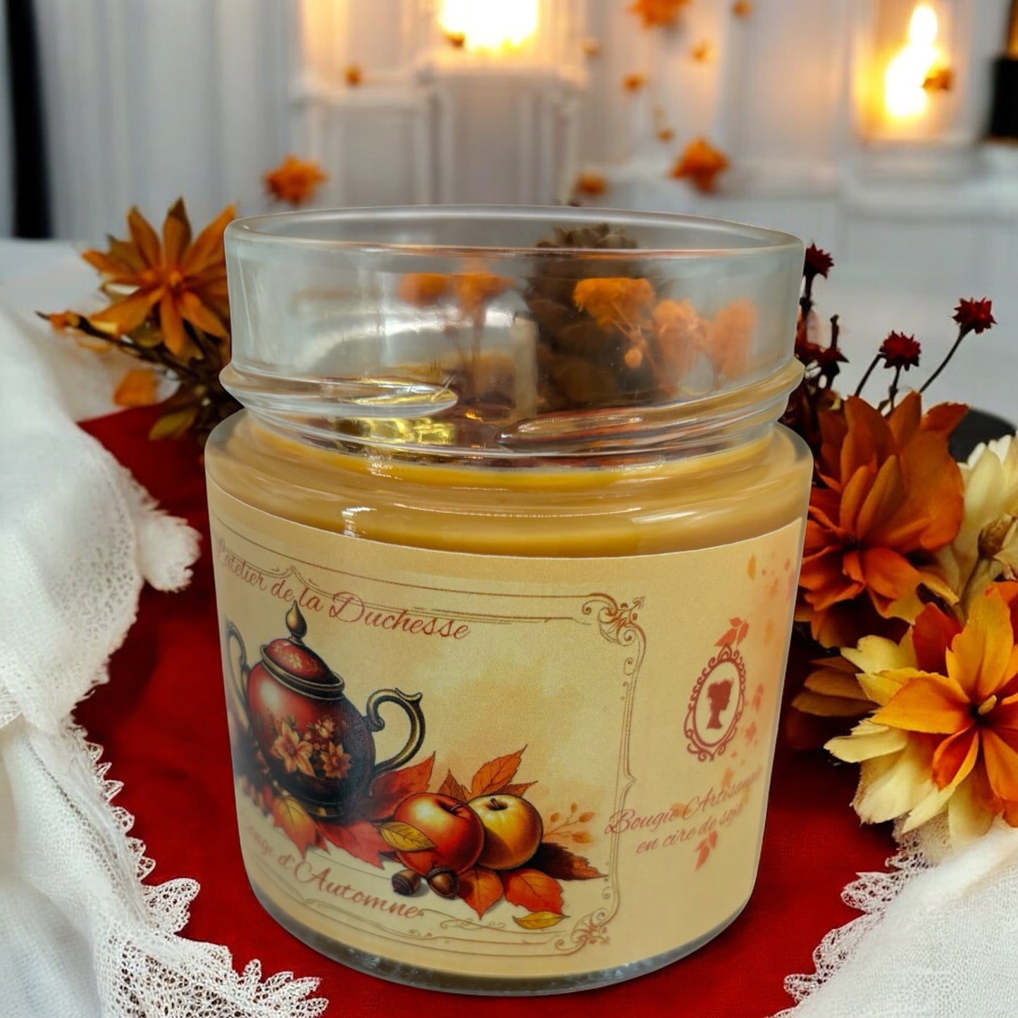 Bougie Songe d’automne in glass jar with autumn decorations, creating a warm and cozy atmosphere.